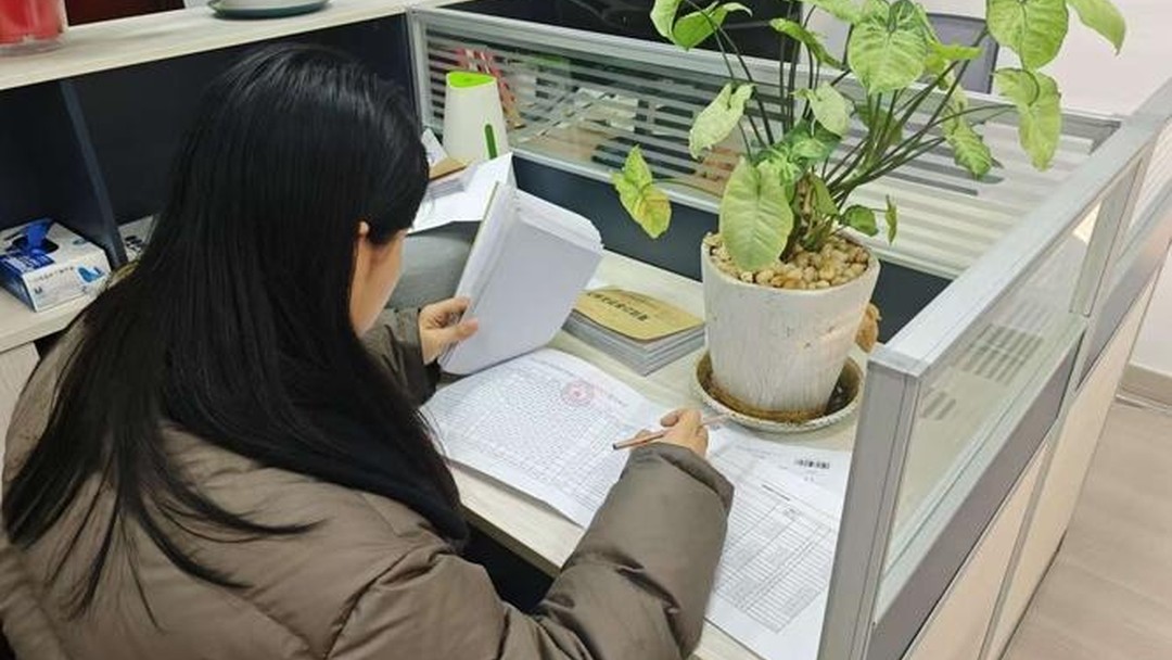 科研人员对着票据和电脑